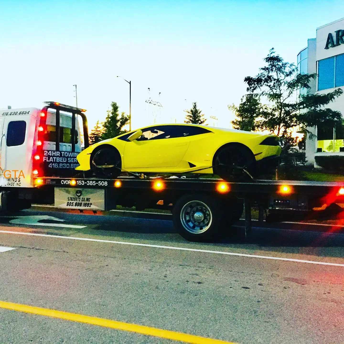 Yellow Lamborghini Huracán secured on a flatbed tow truck